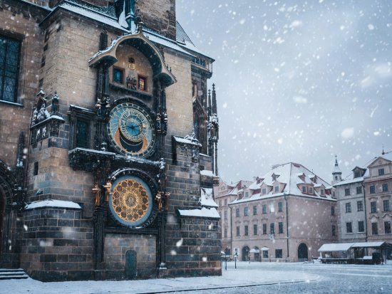 Snow falling across the historic astronomical clock tower in Prague Old Town